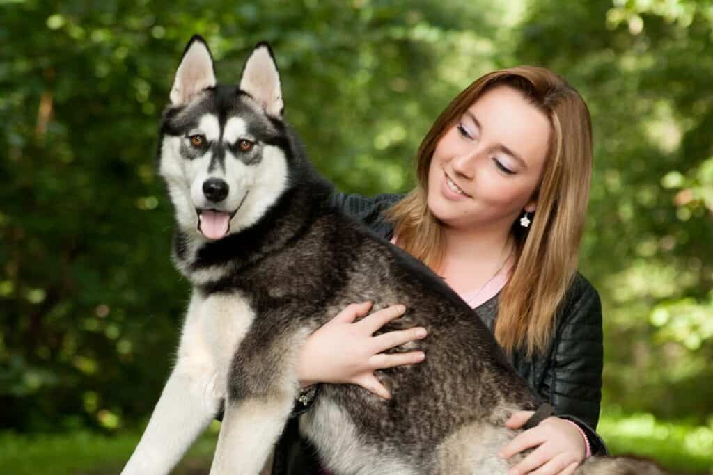 a female owner with a medium siberian husky