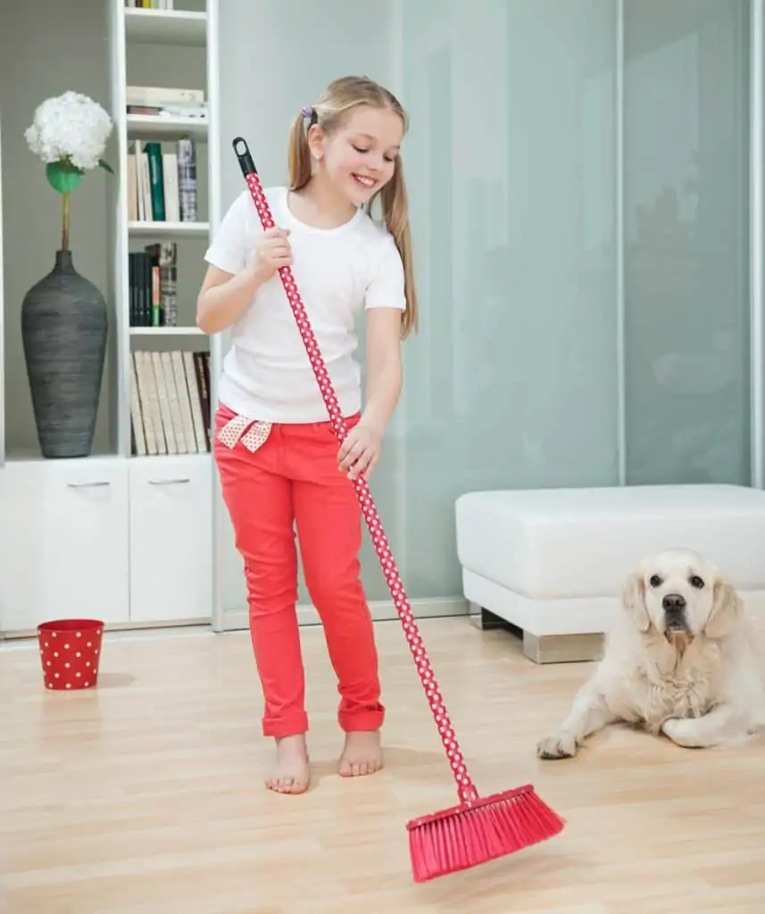 girl sweeping dog hair off floor