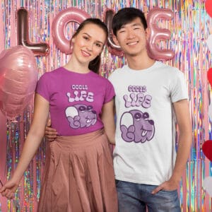man and woman wearing oodle dog tshirts in front of balloons