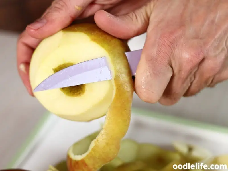 man peeling an apple