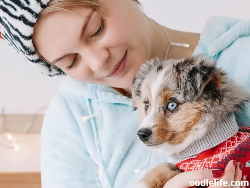 woman cuddles with her puppy
